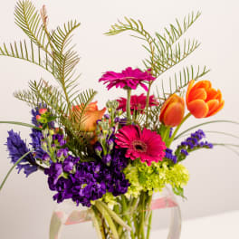 Colorful mixed bouquet in a clear round vase