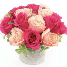 Pink and peach roses arranged in a white vase