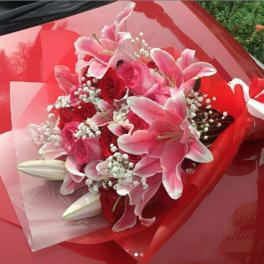 Pink lilies and red roses wrapped in red paper