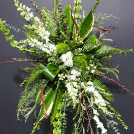 Tall floral spray with white blooms and lush green foliage