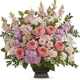 Pink roses and mixed blooms arranged in a dark vase
