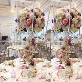 Tall floral centerpiece with pink and white roses at a banquet table
