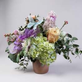 Bouquet of pastel flowers in a terracotta vase with a butterfly decoration