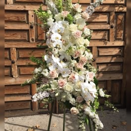 Tall standing floral spray with white orchids, roses, and lilies