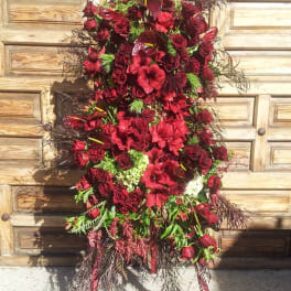 Tall red floral standing spray with roses and lilies