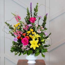 Mixed bouquet with pink roses and yellow lilies in a white vase