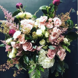 Pink and white rose arrangement in a gray vase
