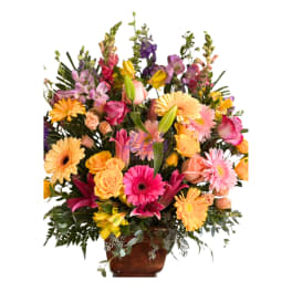 Mixed bouquet of pink, yellow, and orange flowers in a vase