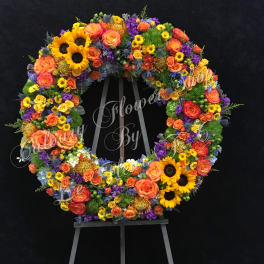 Large circular floral wreath on an easel with sunflowers and roses