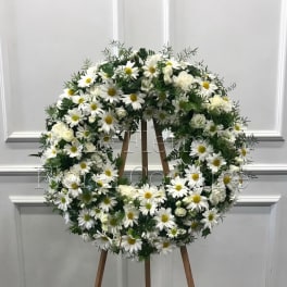 White daisy and rose wreath on a wooden easel