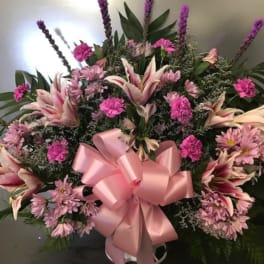 Pink and white floral spray with a large pink ribbon