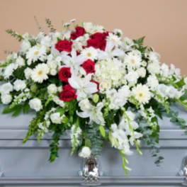 White and red floral casket spray with roses and daisies