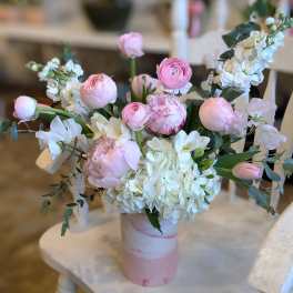 Pink and white floral arrangement in a pink vase