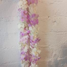 Two hanging orchid leis in pink and white