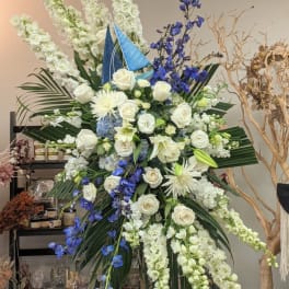 Large standing floral arrangement with white roses and blue flowers