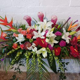 Large tropical floral arrangement with white lilies and red anthuriums