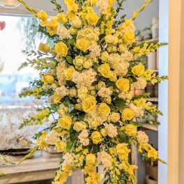 Tall yellow and white floral standing arrangement on an easel