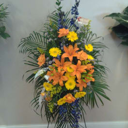 Tall standing floral spray with orange lilies and yellow daisies