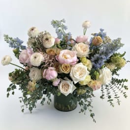 Large pastel bouquet in a dark glass vase