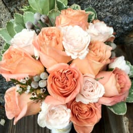 Bouquet of peach and white roses with variegated greenery