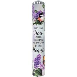 Tall memorial candle with purple flowers and birds