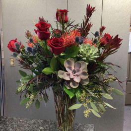 Tall vase arrangement with red roses and succulents
