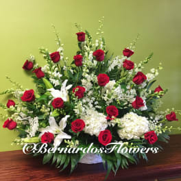 Large arrangement of red roses and white lilies in a white basket