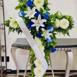 Blue and white funeral spray with a memorial ribbon