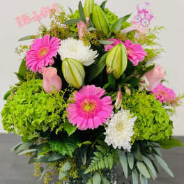 Pink gerbera daisies and white chrysanthemums in a glass vase