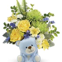 Yellow and white flowers arranged in a blue teddy bear vase
