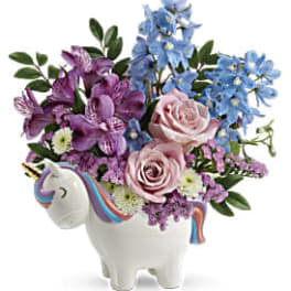 Pink and blue flowers arranged in a unicorn-shaped vase