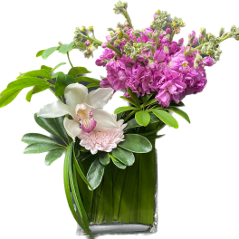 Pink flowers and a white orchid in a clear glass vase