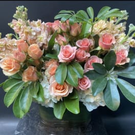 Pink and peach roses arranged in a glass vase