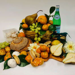 Fruit and bread gift basket with flowers and a green bottle