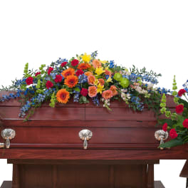 Casket surrounded by colorful funeral flower sprays