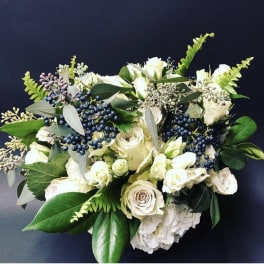White rose bouquet with dark blue berries and green foliage