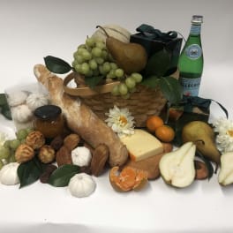 Gift basket with fruit, bread, cheese, pastries, and a bottle of sparkling water