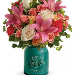 Bouquet of pink lilies and roses in a teal ceramic vase