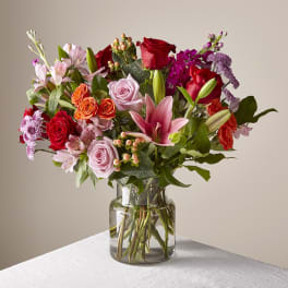 Mixed bouquet of roses, lilies, and alstroemeria in a glass vase