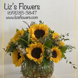 Sunflower arrangement in a round glass vase