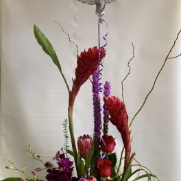 Tall floral arrangement with a thank-you balloon and mixed blooms in a vase