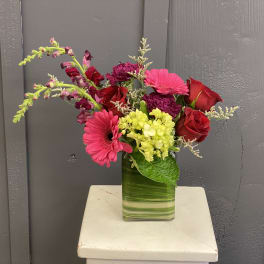 Mixed bouquet of red and pink flowers in a glass vase