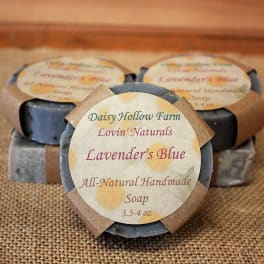 Three bars of lavender-blue handmade soap with paper labels