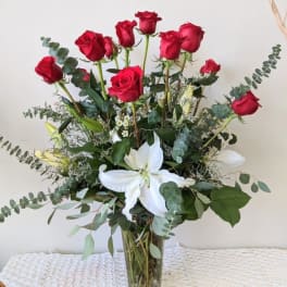Bouquet of red roses and white lilies in a clear glass vase
