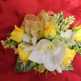 Small yellow and white floral corsage with ribbon on red fabric
