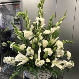White floral arrangement in a white wicker basket
