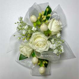 White rose corsage with silver ribbon and small white filler flowers