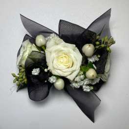 White rose corsage with black ribbon and small white berries