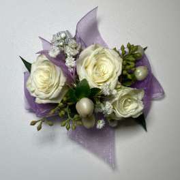 Small corsage with white roses and purple ribbon
