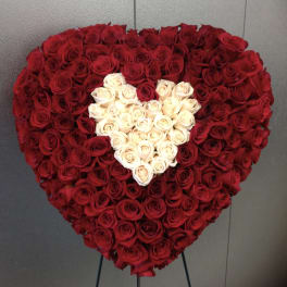 Heart-shaped arrangement of red and white roses on a stand